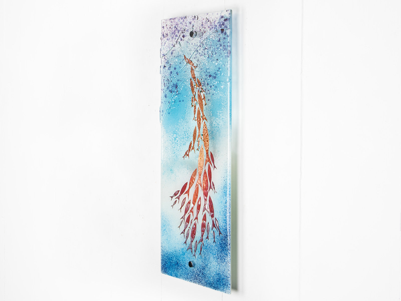 Fused glass wall panel in an ocean inspired design with copper fish and soft ocean colours. 