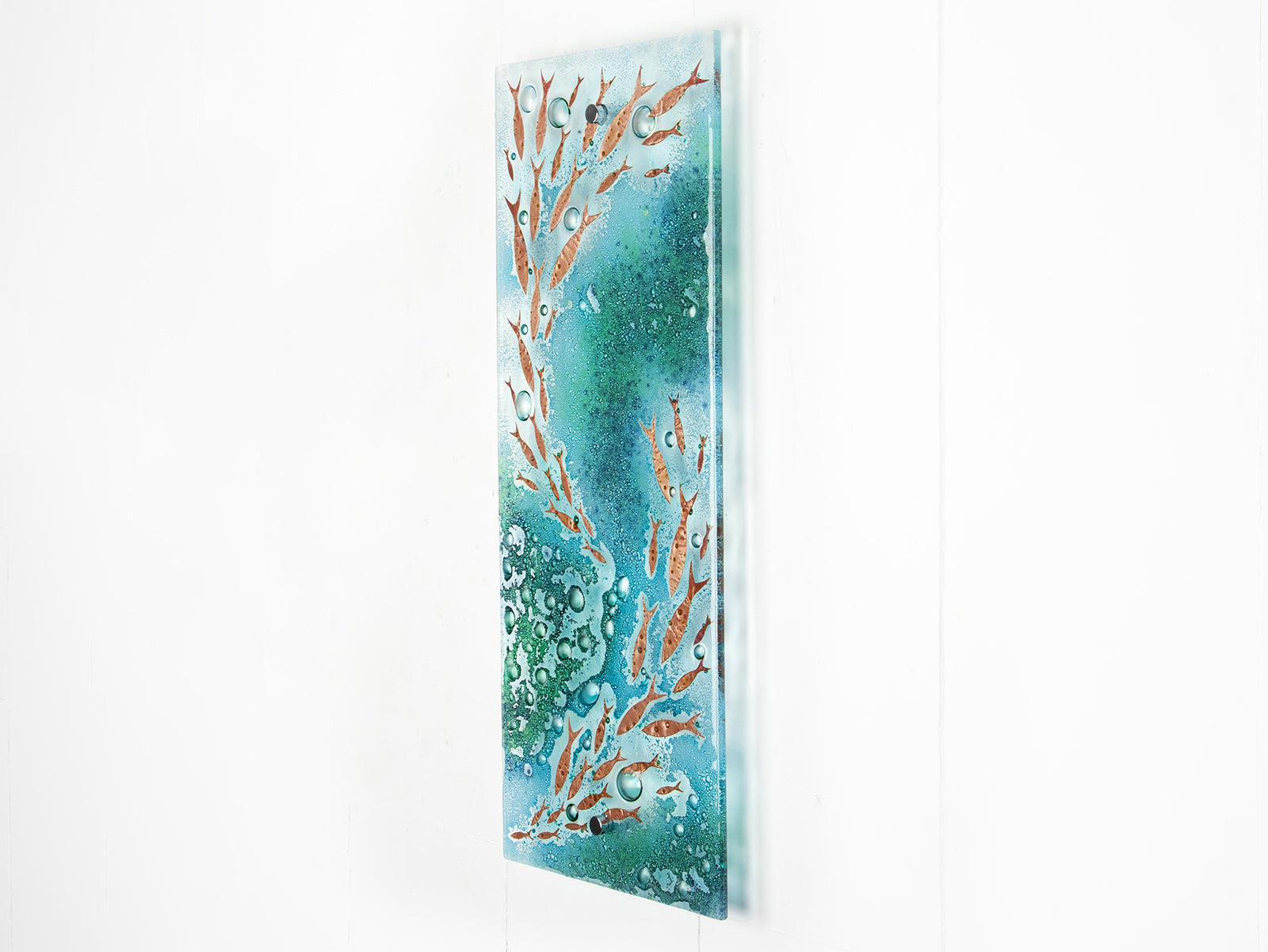 Fused glass wall panel with coastal green colours and copper fish. A wall art piece inspired by the ocean.