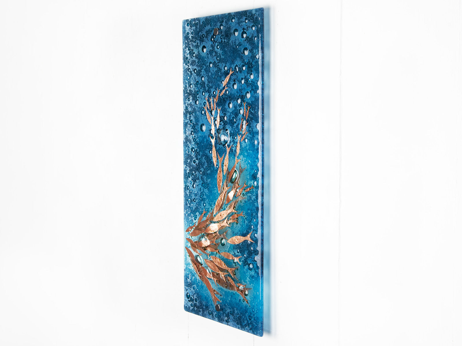 Fused glass wall panel with bubbled blue colours and swimming copper fish. An organic and ocean inspired piece of wall art. 