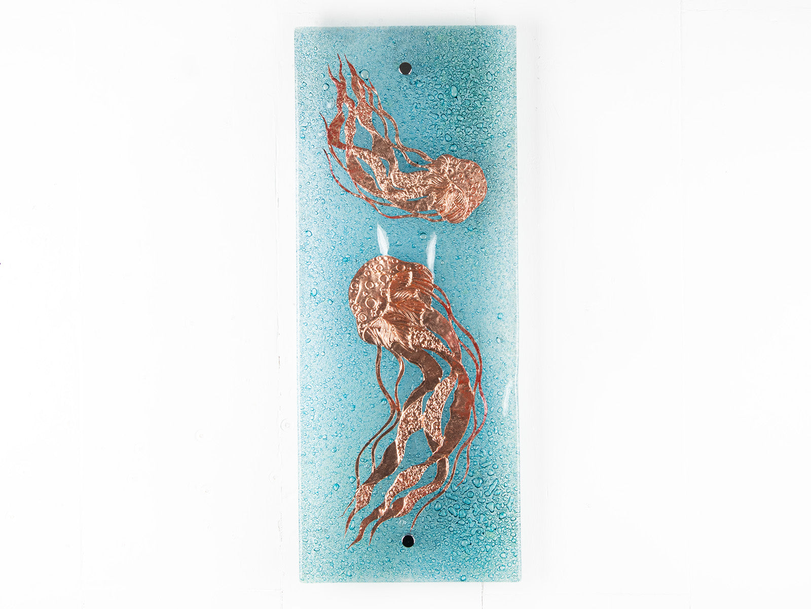 Fused glass wall panel featuring a hand-etched, copper jellyfish design on a aqua bubble blue background. 