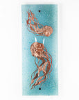 Fused glass wall panel featuring a hand-etched, copper jellyfish design on a aqua bubble blue background. 