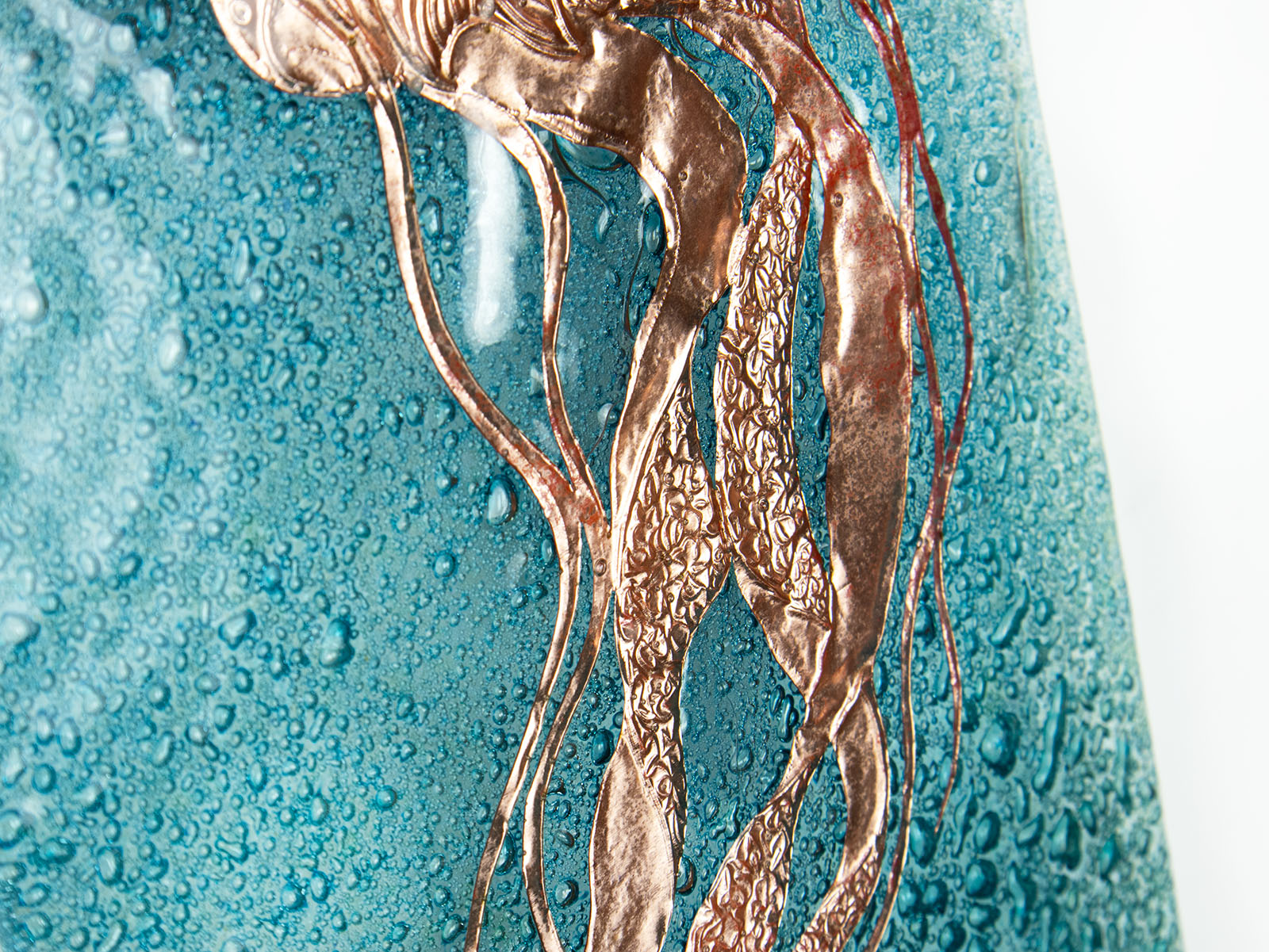 Details of hand-etched copper jellyfish on a fused glass wall panel, inspired by the sea. 