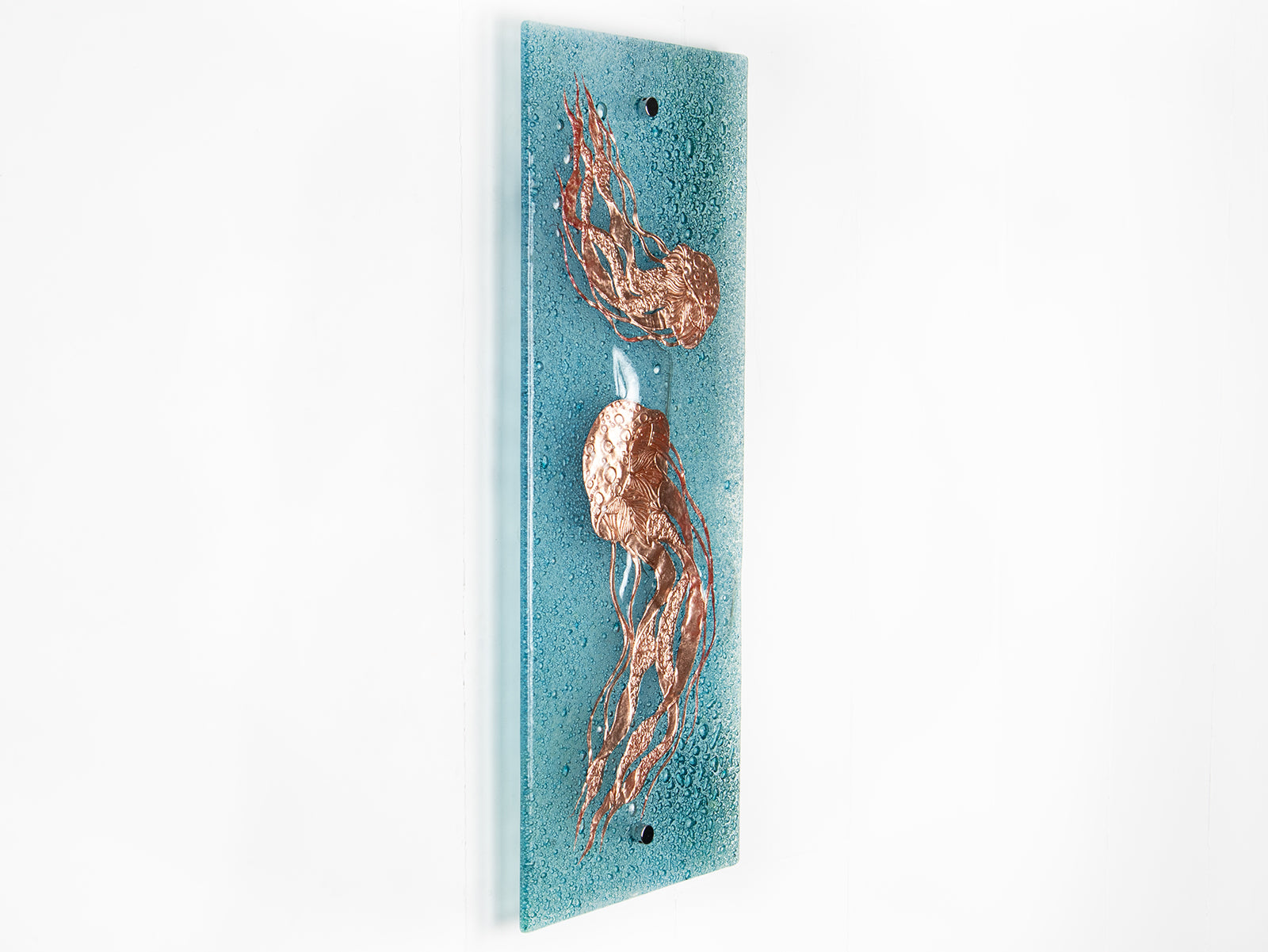 Fused glass wall panel featuring a hand-etched, copper jellyfish design on a aqua bubble blue background. 