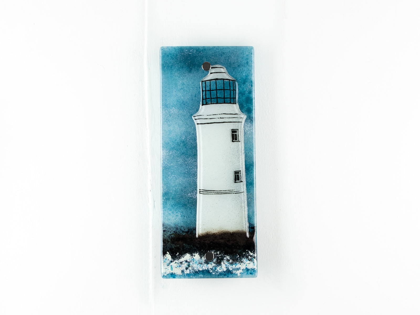 Small fused glass wall panel, featuring a lighthouse design in a teal blue colour-way. 