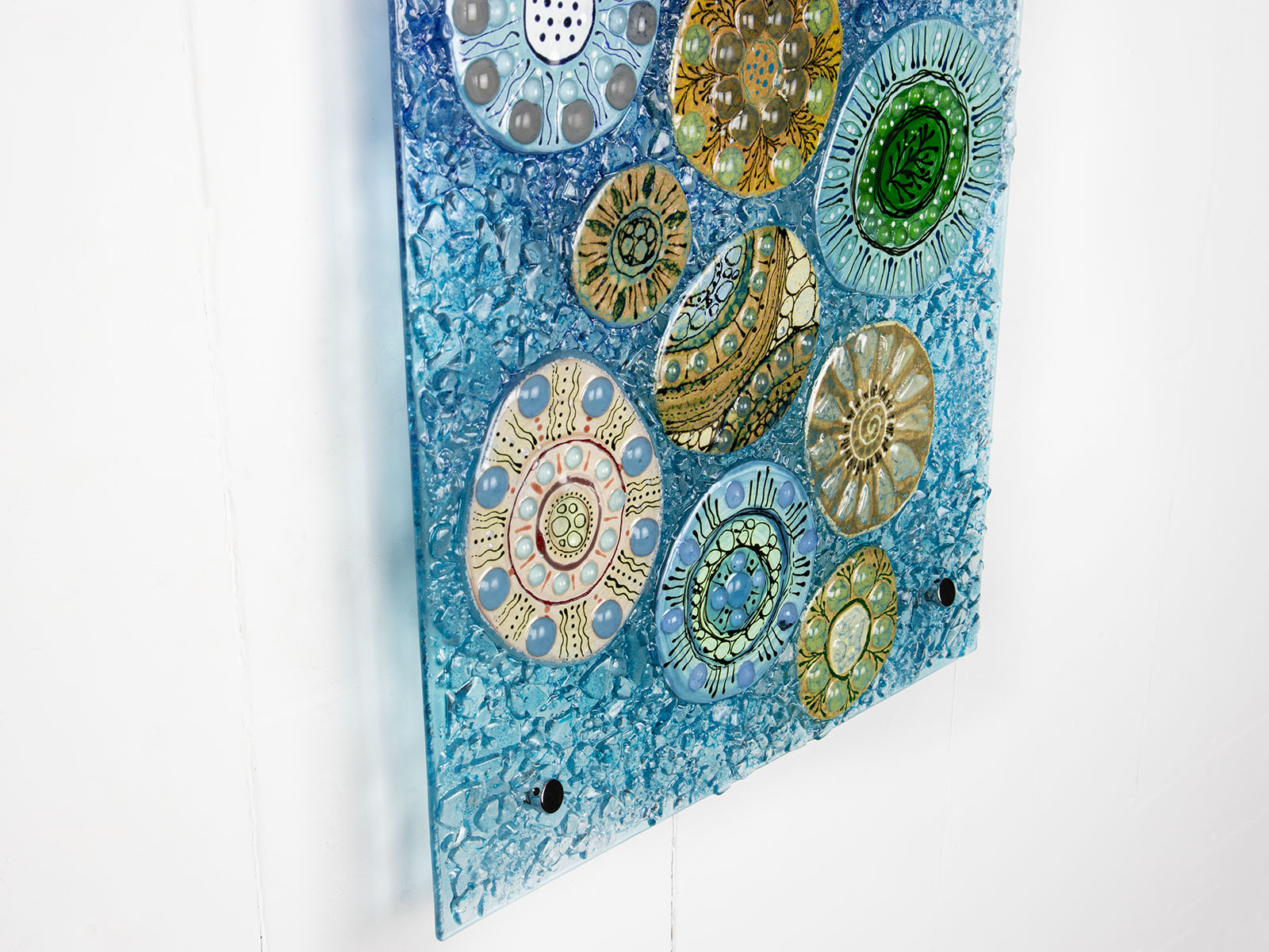 Fused glass wall panel, designed with organic textural detail and aqua, marine blues.