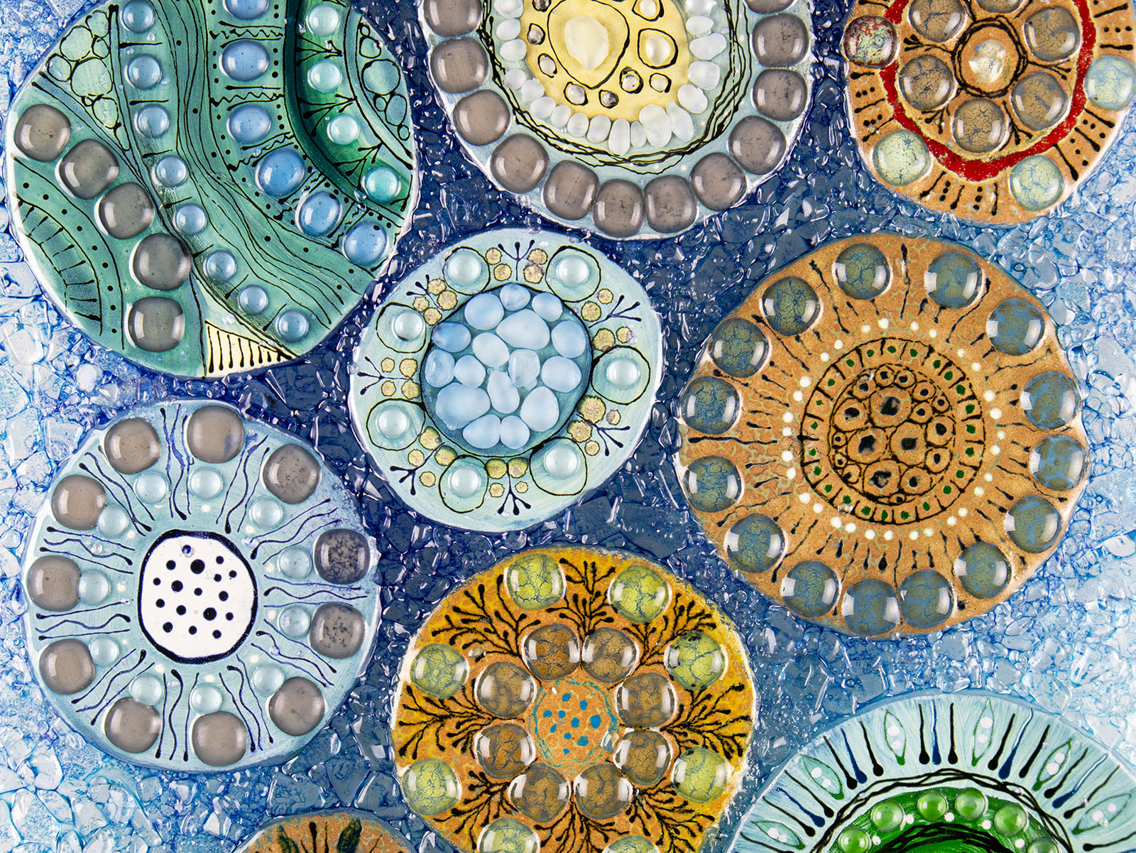 Close up of fused glass wall panel, designed with organic textural detail and aqua, marine blues.