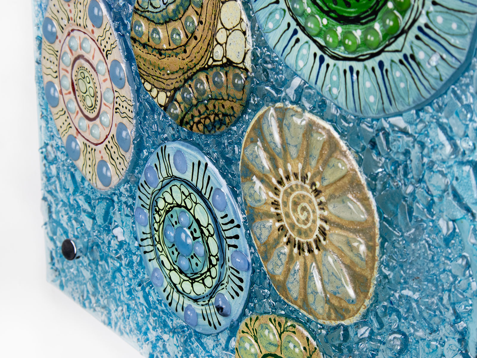 Close up of fused glass wall panel, designed with organic textural detail and aqua, marine blues.