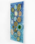 Side image of fused glass wall panel, designed with organic textural detail and aqua, marine blues.