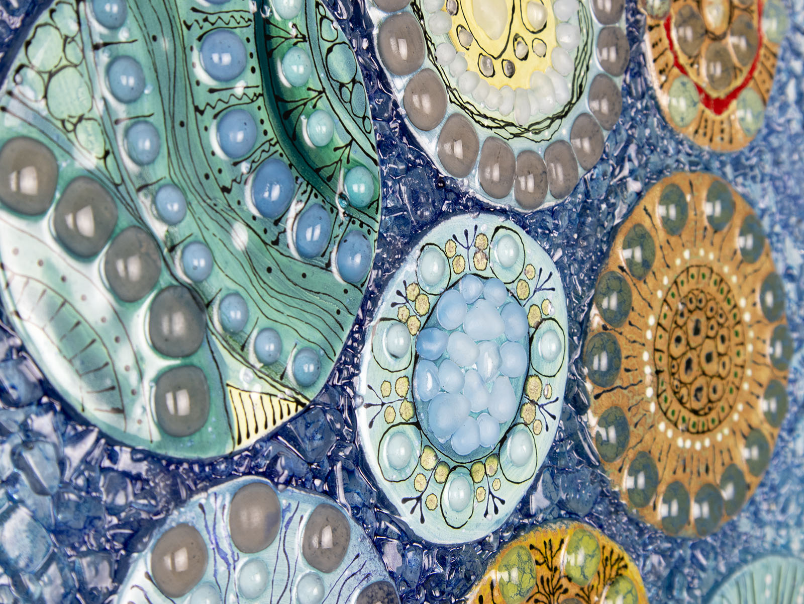 Details of fused glass wall panel, designed with organic textural detail and aqua, marine blues.