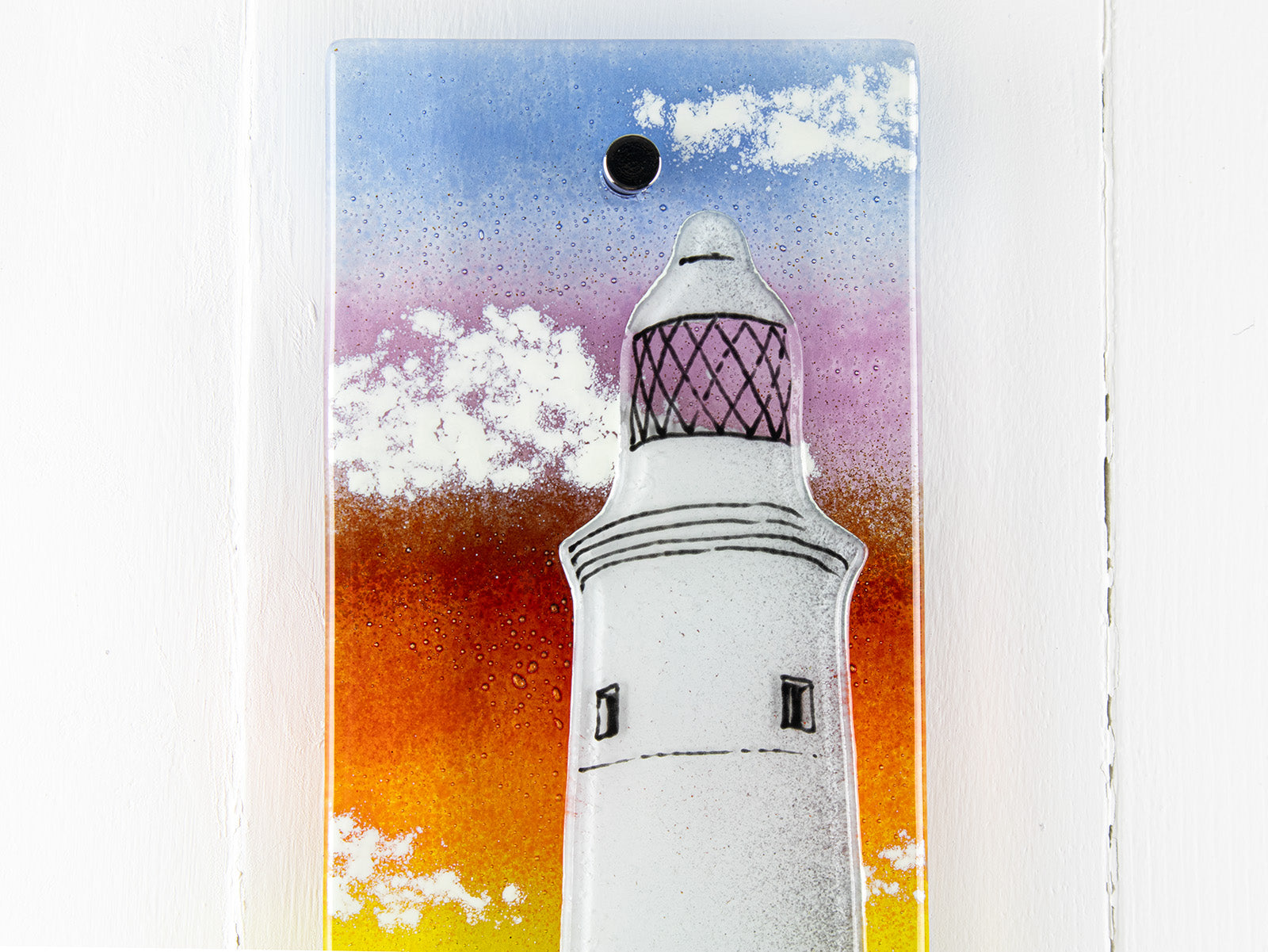 Details of handmade wall panel featuring a lighthouse with bright sunset colours. Gorgeous Artisan wall art piece, designed in Cornwall. 