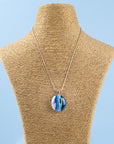 Fused glass pendant necklace, handmade in coastal blues, hung on a sterling silver chain. 
