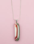 Close up of fused glass pendant necklace, handmade in sea greens and rose pinks, hung n sterling silver chain. 