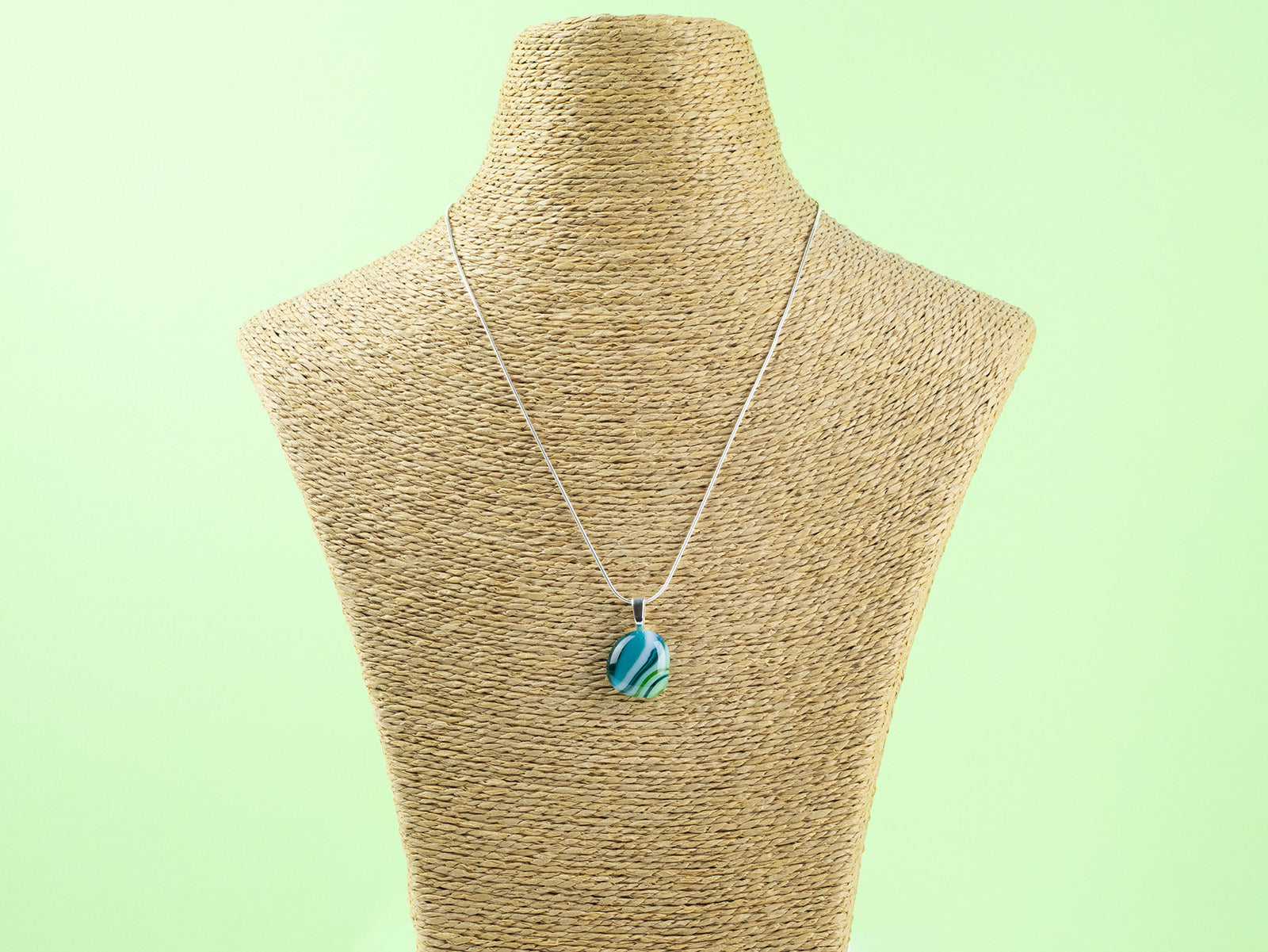 Fused glass pendant necklace, handmade with spring greens and hung on a sterling silver chain. 