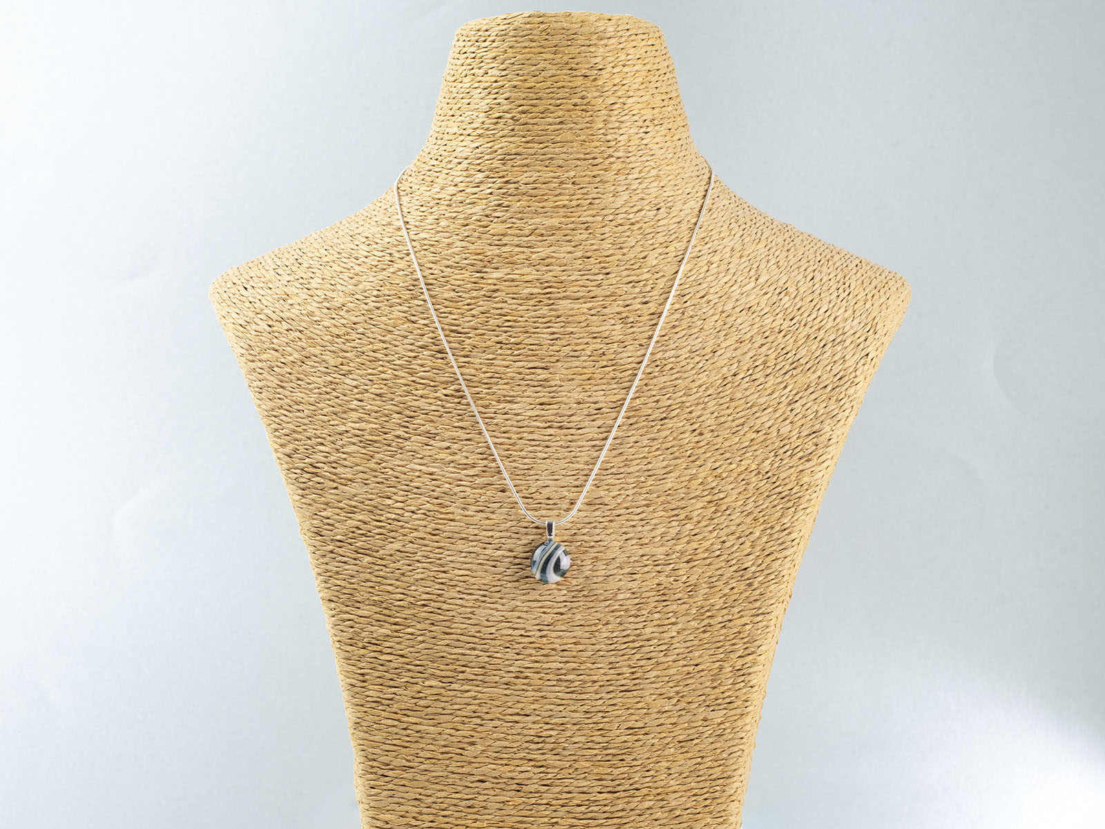 Fused glass pendant necklace, handmade in soft coastal hues, hung on a sterling silver chain. 