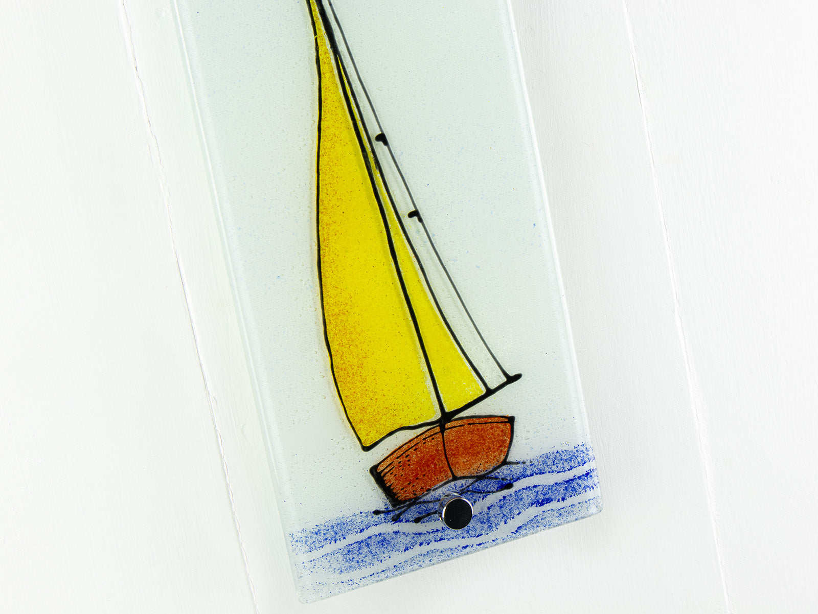 Close up of fused glass panel with a sail boat design and coastal colours. 