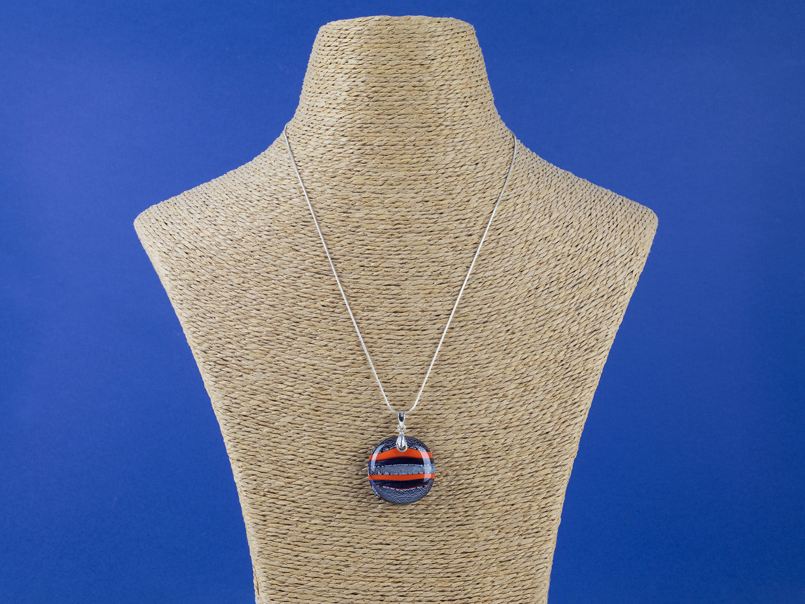 Fused glass large pendant necklace in vibrant orange and purple colours. Handmade and features sterling silver chain and fixings.
