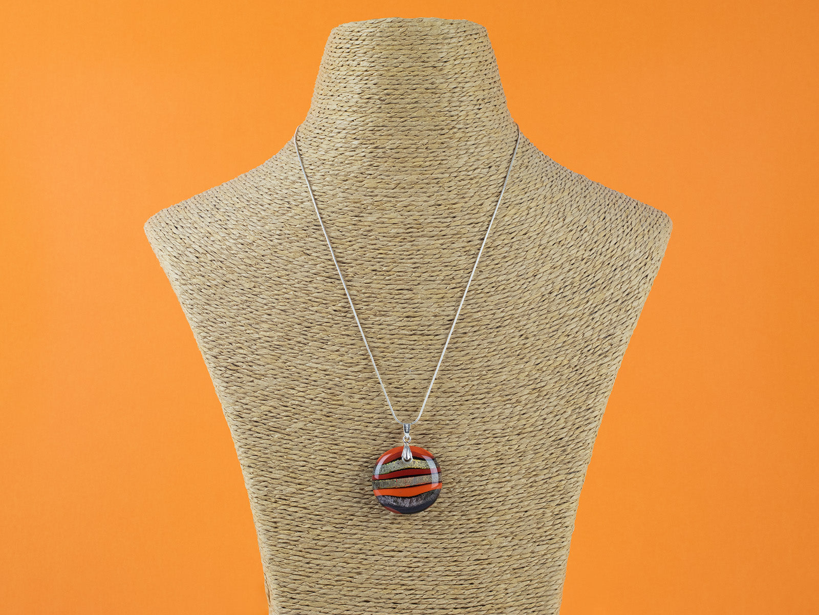 Fused glass large pendant necklace in vibrant orange colours. Handmade and features sterling silver chain and fixings.