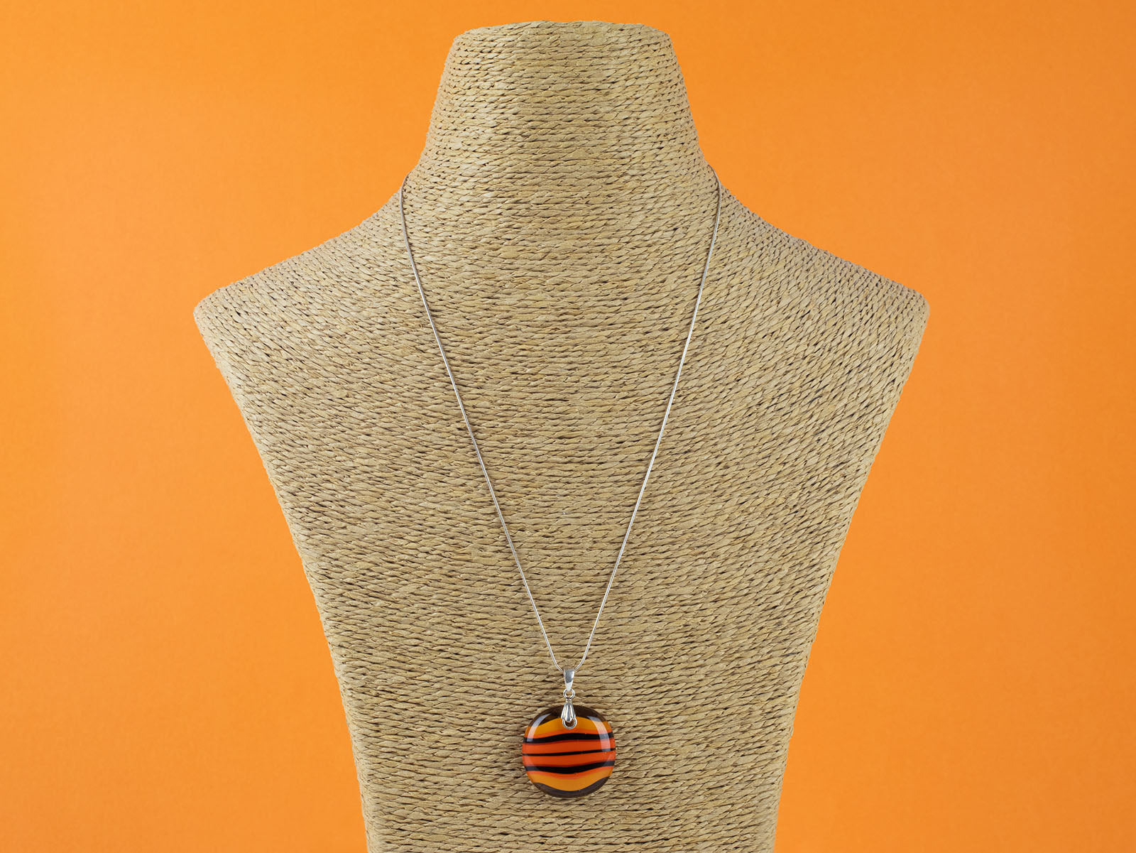 Fused glass large pendant necklace in vibrant orange colours. Handmade and features sterling silver chain and fixings.