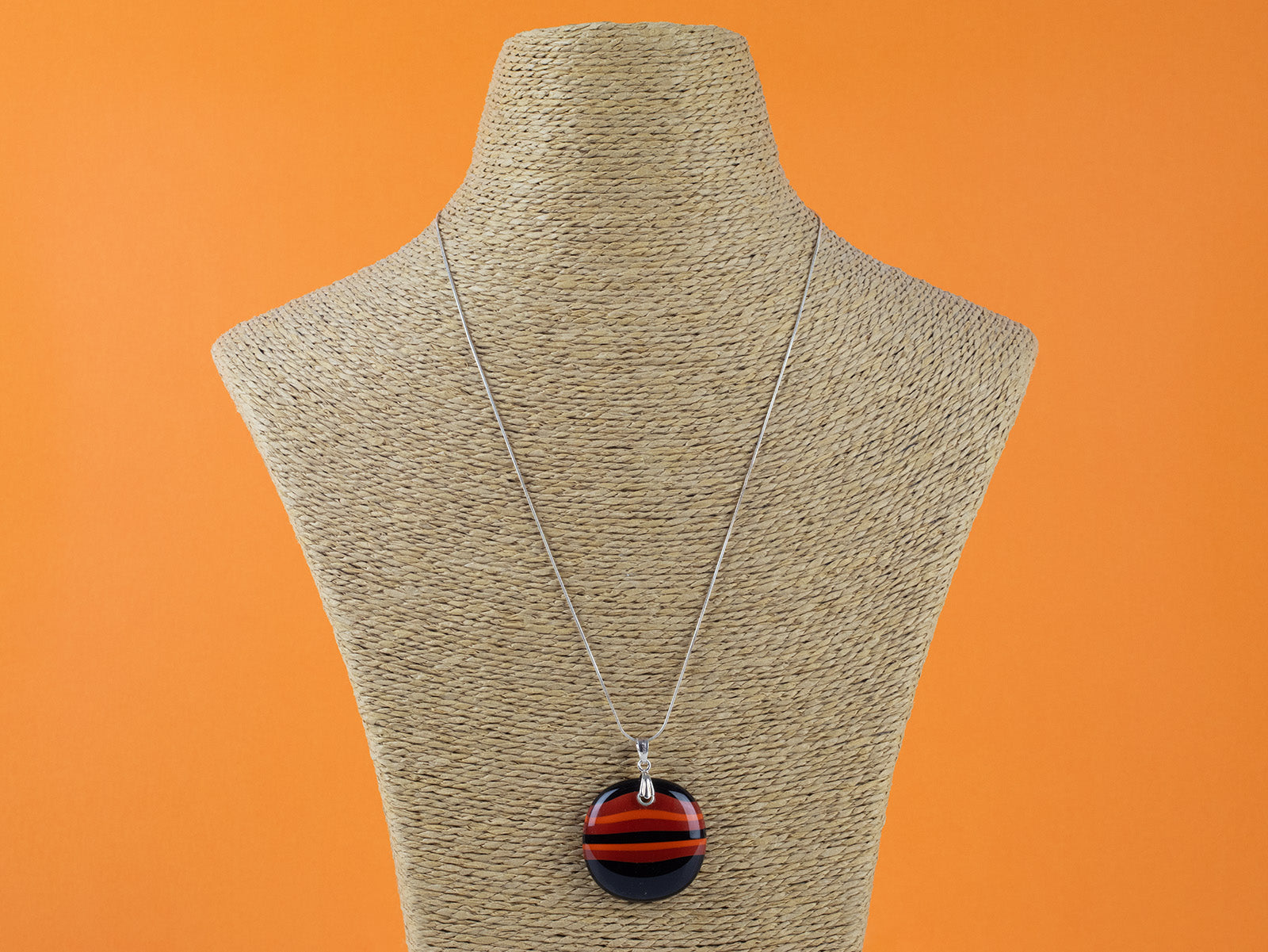 Fused glass large pendant necklace in vibrant orange colours. Handmade and features sterling silver chain and fixings.
