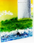 Artistic depiction of a landscape with green grass, blue water, and white clouds on a wall panel. 