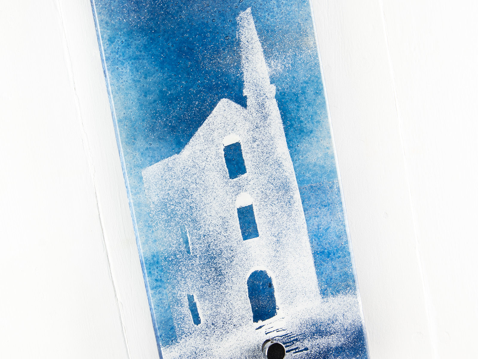 Close up of a tin mine with bright teal background on a fused glass wall panel. 