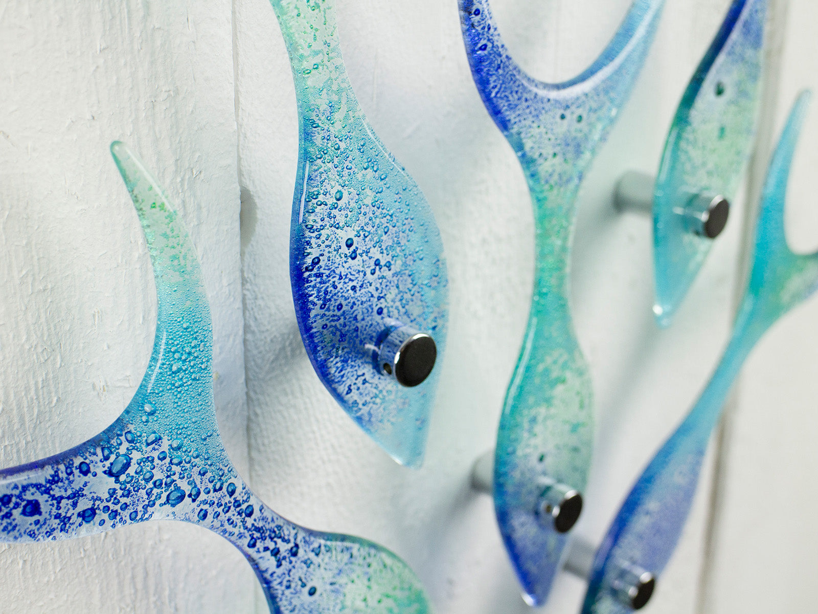 Close up of fused glass fish blue and green wall art with fittings