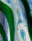 Close up of glass fish on a fused glass oblong art frame with coastal greens and textural blues.