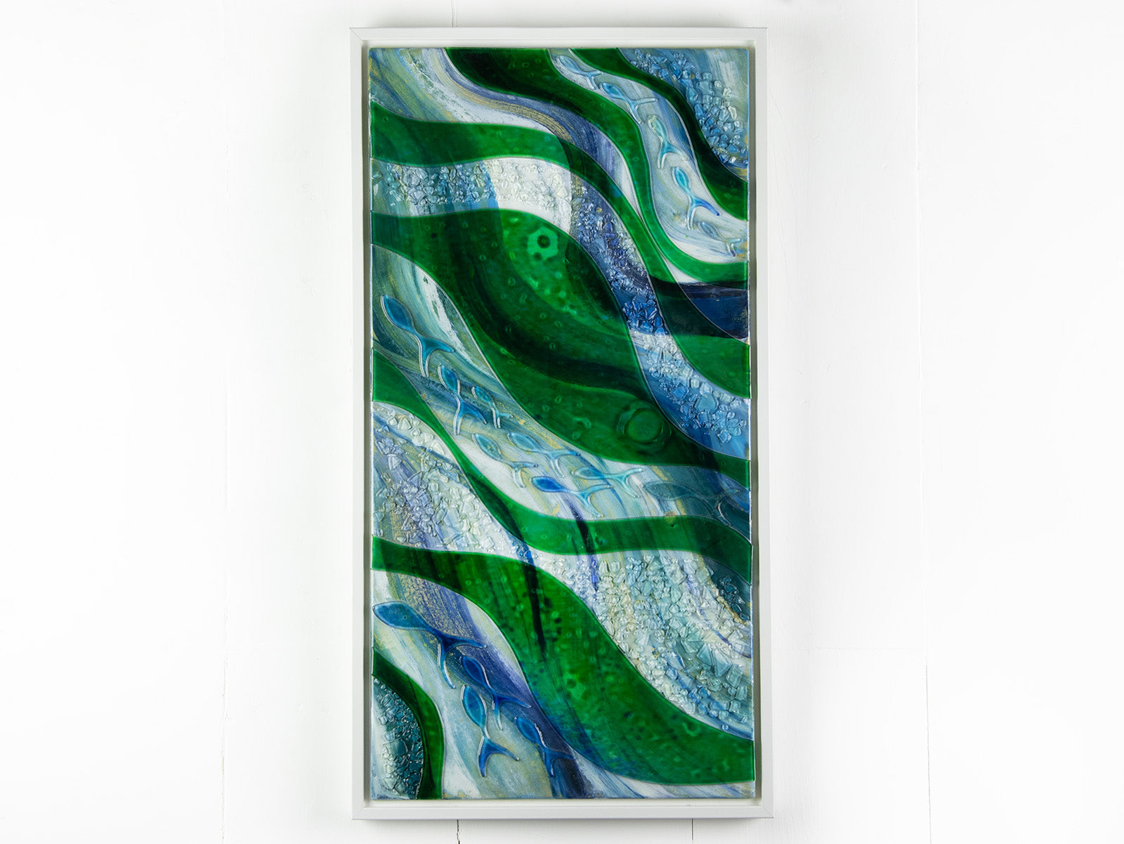 Fused glass oblong art frame with coastal greens and textural blues with glass fish. 