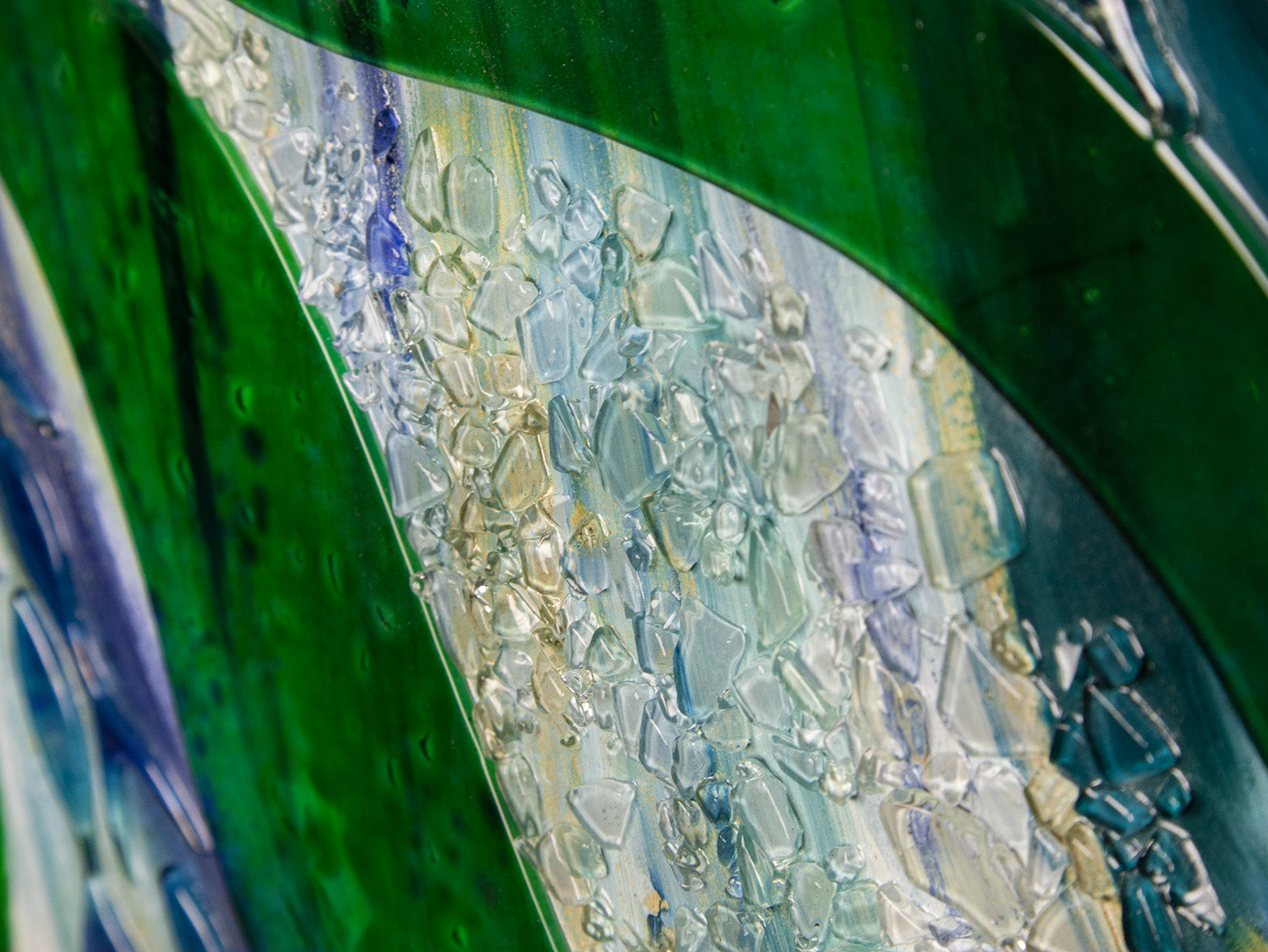 detail of organic glass texture on a fused glass oblong art frame with coastal greens.