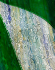 detail of organic glass texture on a fused glass oblong art frame with coastal greens.