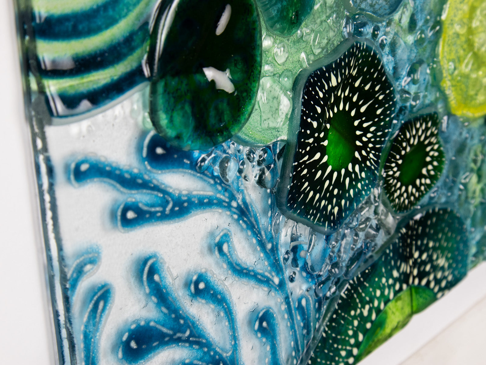 Close up of intricate ocean reef inspired fused glass art frame. Bright ocean blue colours and handmade wall art. 