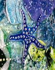 Close up of intricate ocean reef inspired fused glass art frame. Bright ocean blue colours and handmade wall art. 