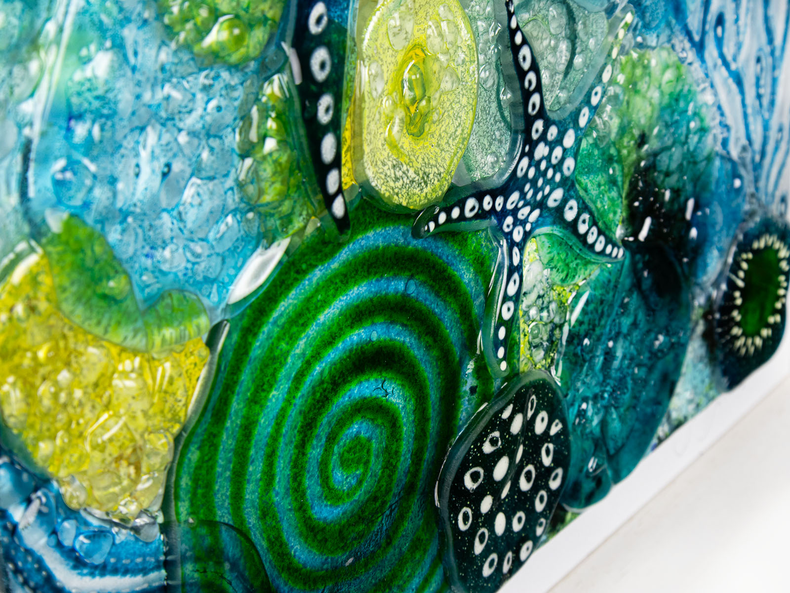 Close up of intricate ocean reef inspired fused glass art frame. A vibrant and handmade piece of wall art. 