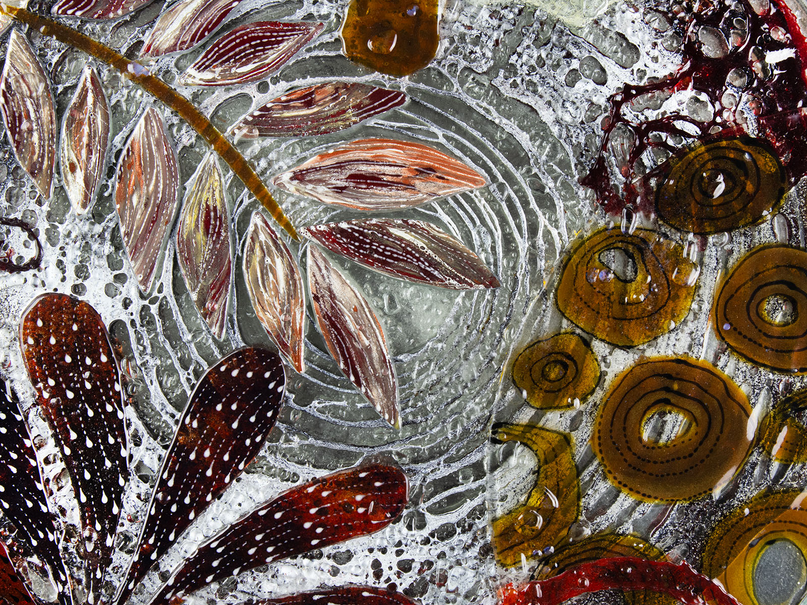 Close up of fused glass round wall panel, made from fused glass, inspired by the autumnal country-side. Striking, handmade wall art with organic texture. 