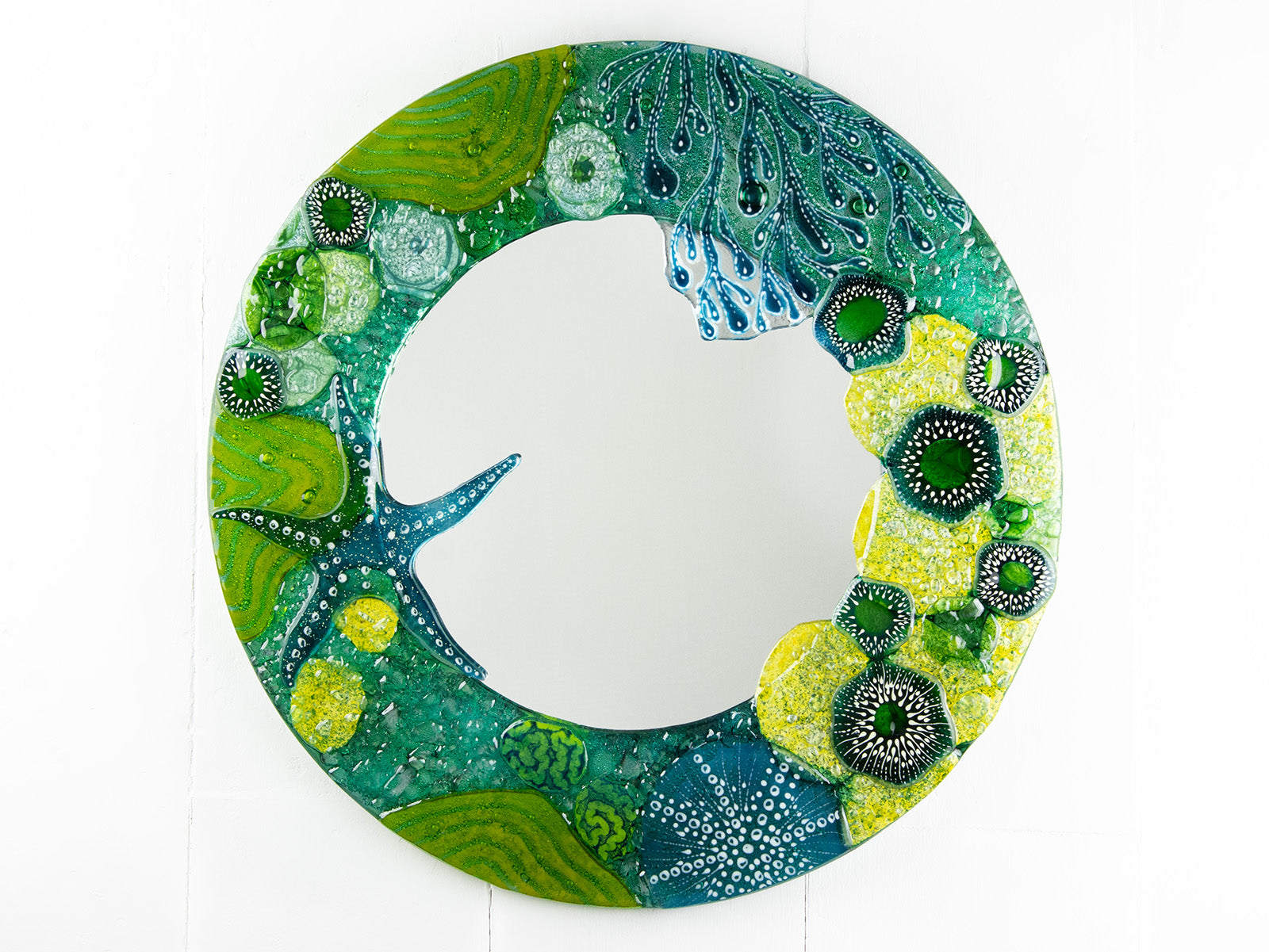 Round mirror made from fused glass in ocean inspired design with sea green colours. Handmade, bespoke wall art. 