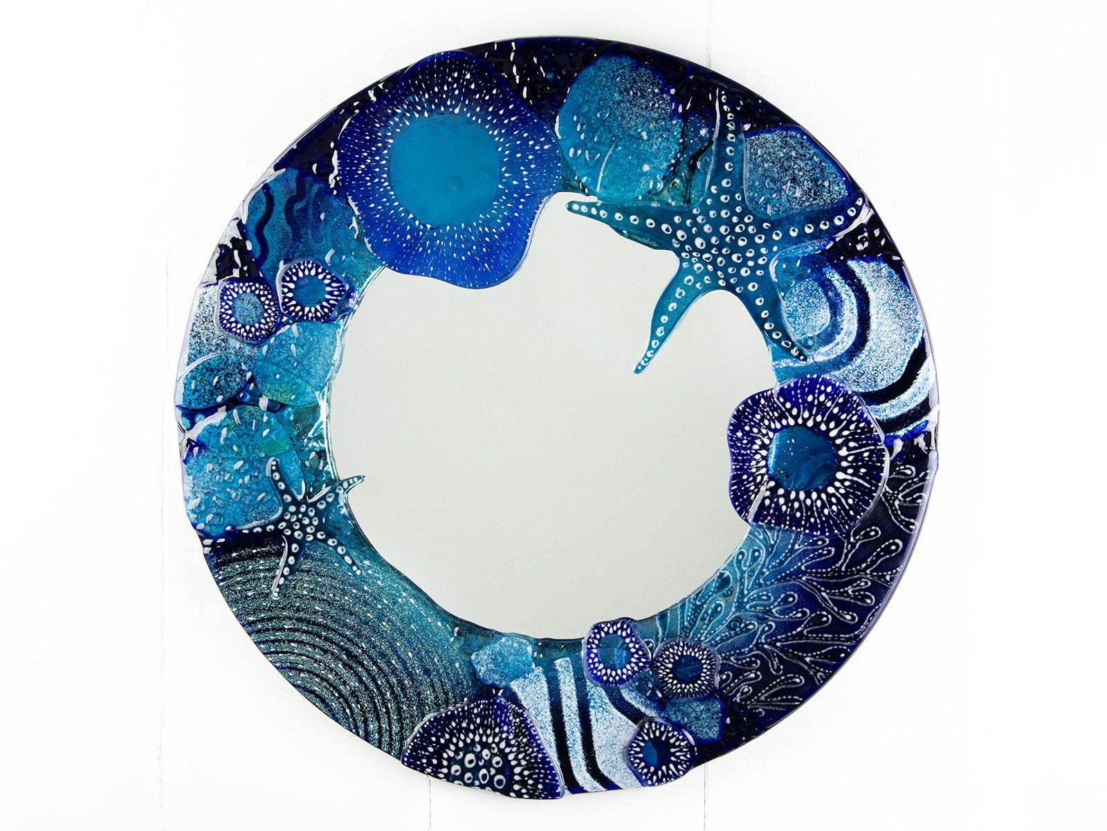 Round mirror, made from fused glass with hand-painted ocean designs. Coastal blue colour-way, handmade and bespoke wall art.