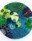 Round wall panel made from fused glass, inspired by the ocean reefs with starfish detailing and coastal colours. 