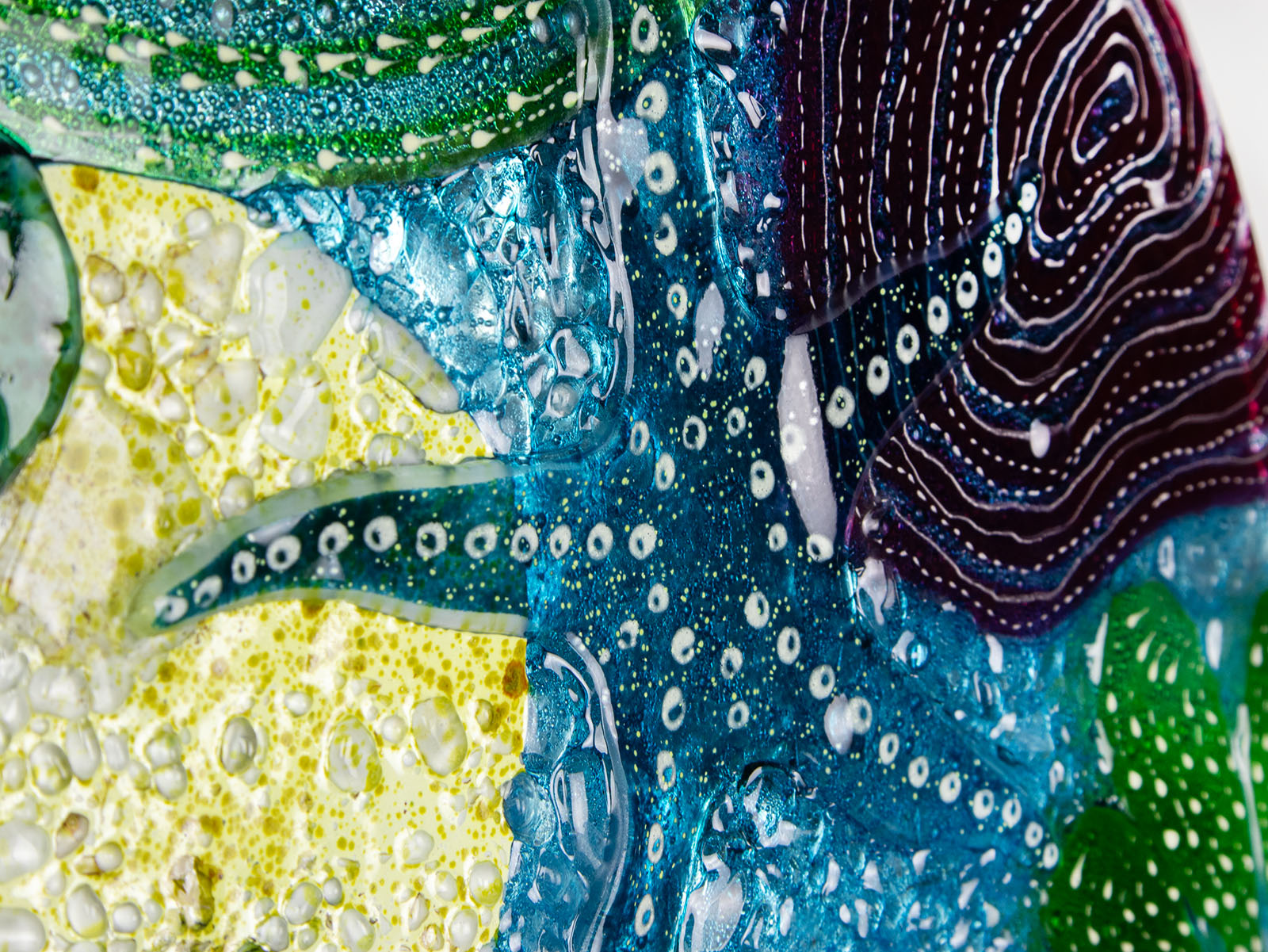 Stunning close up of round wall panel made from fused glass, inspired by the ocean reefs with starfish detailing and coastal colours. 