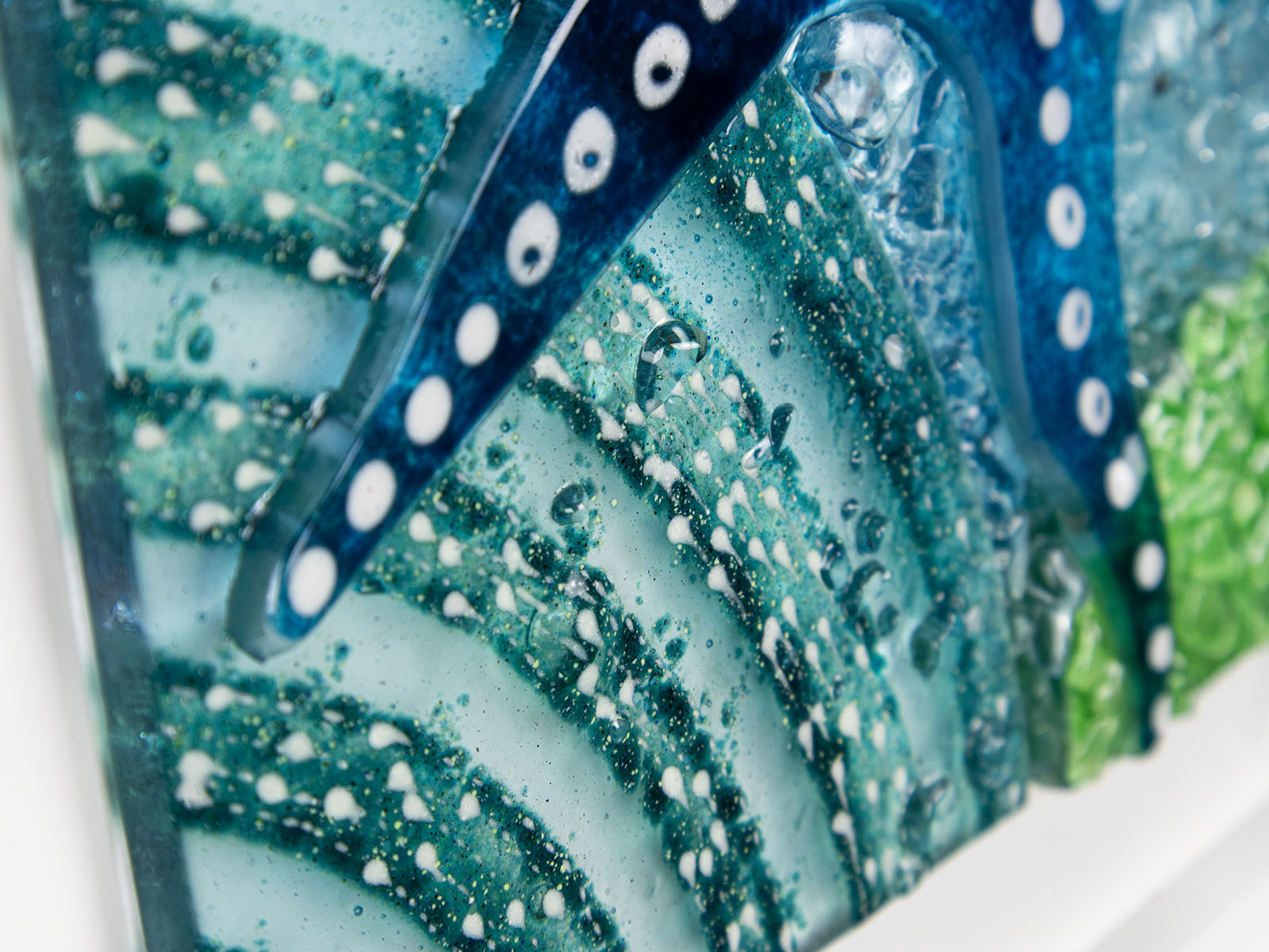 Highly detailed image of fused glass art frame inspired by the ocean, created with texture and coastal colours with pink hues. A unique piece of wall art, handmade in Cornwall, Launceston. 