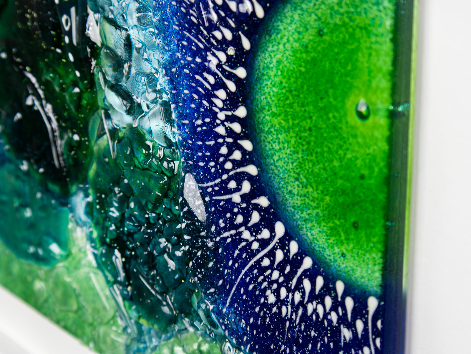 Close up of fused glass art frame, inspired by the ocean with lots of texture and bright coastal colours. A unique piece of wall art, handmade in Cornwall, Launceston. 