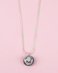Close up of fused glass pendant necklace, handmade with earthy pinks. Stunning jewellery with sterling silver chain. 