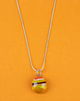 Close up of fused glass pendant necklace, handmade with sunset orange and yellow colours. Stunning jewellery with sterling silver chain. 