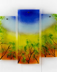 Fused glass quintych featuring an abstract design of a woodland, with a vibrant sunset sky and textured detailing. 