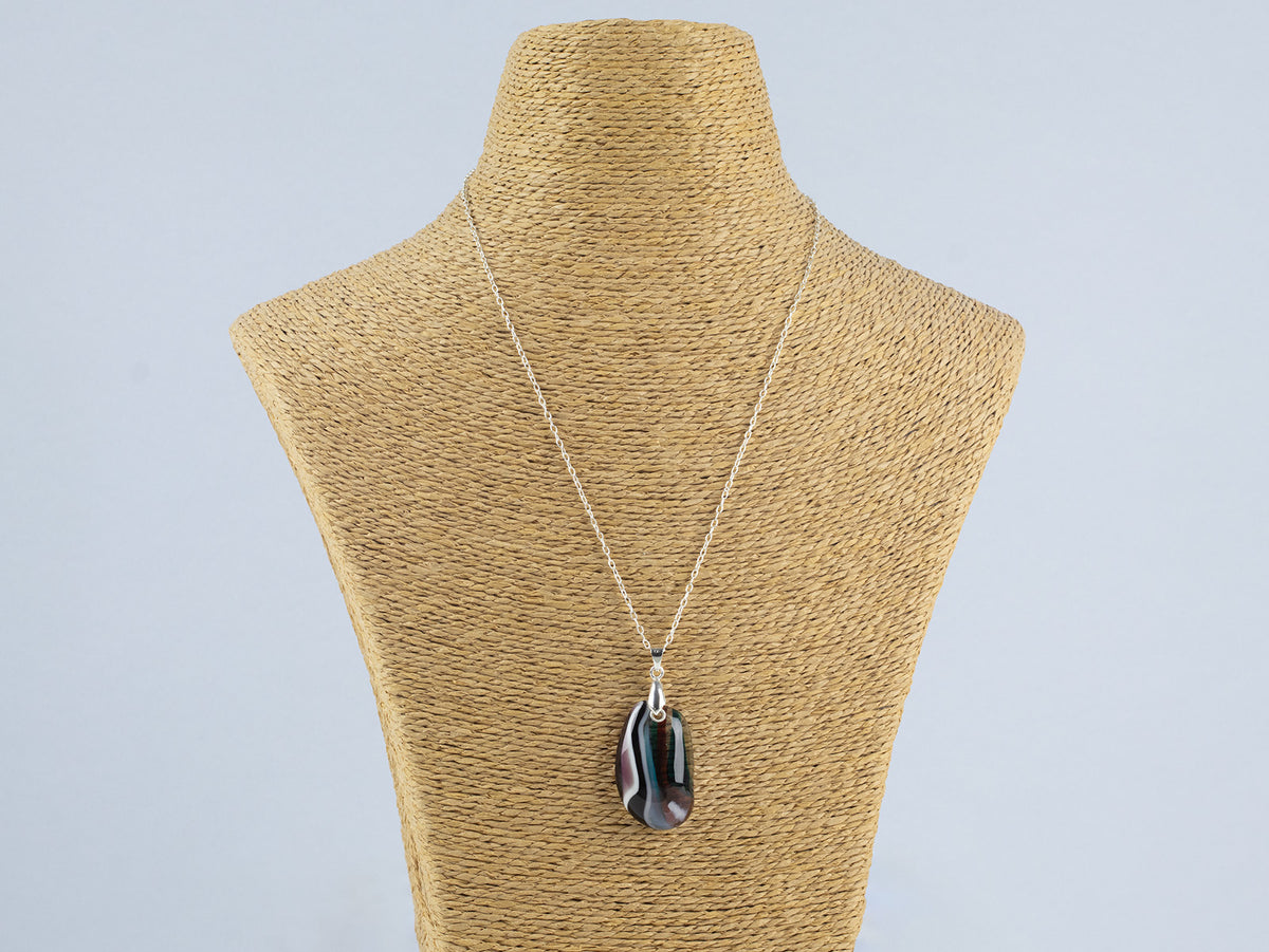 A fused glass pendant necklace, handmade in organic soft hues, hung on a sterling silver chain. 