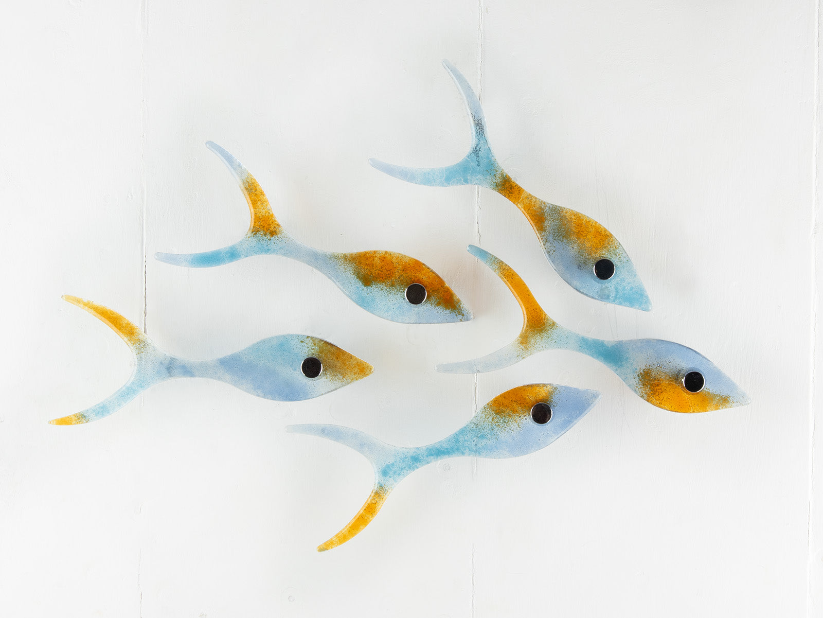 Small display of fused glass fish, individually handmade in sunset orange and sea blue colours. 