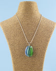 An artisan fused glass pendant necklace, handcrafted in our studio in soft coastal colours. Finished with a sterling silver chain and fittings, shown on a mannequin. 
