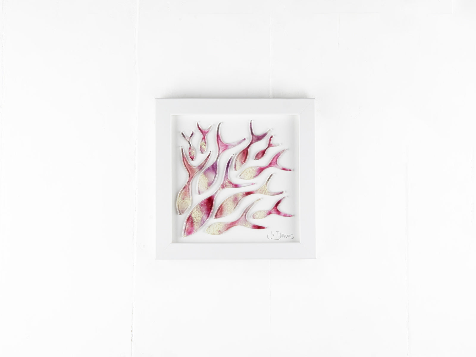 Art frame with hand-cut fused glass shoal of fish in a sunset pink colour-way, inspired by the ocean.