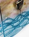 Textured detailed on a fused glass triptych depicting a serene harbour scene with hand-painted sailboats on blue water under a pastel sky with hills in the distance.