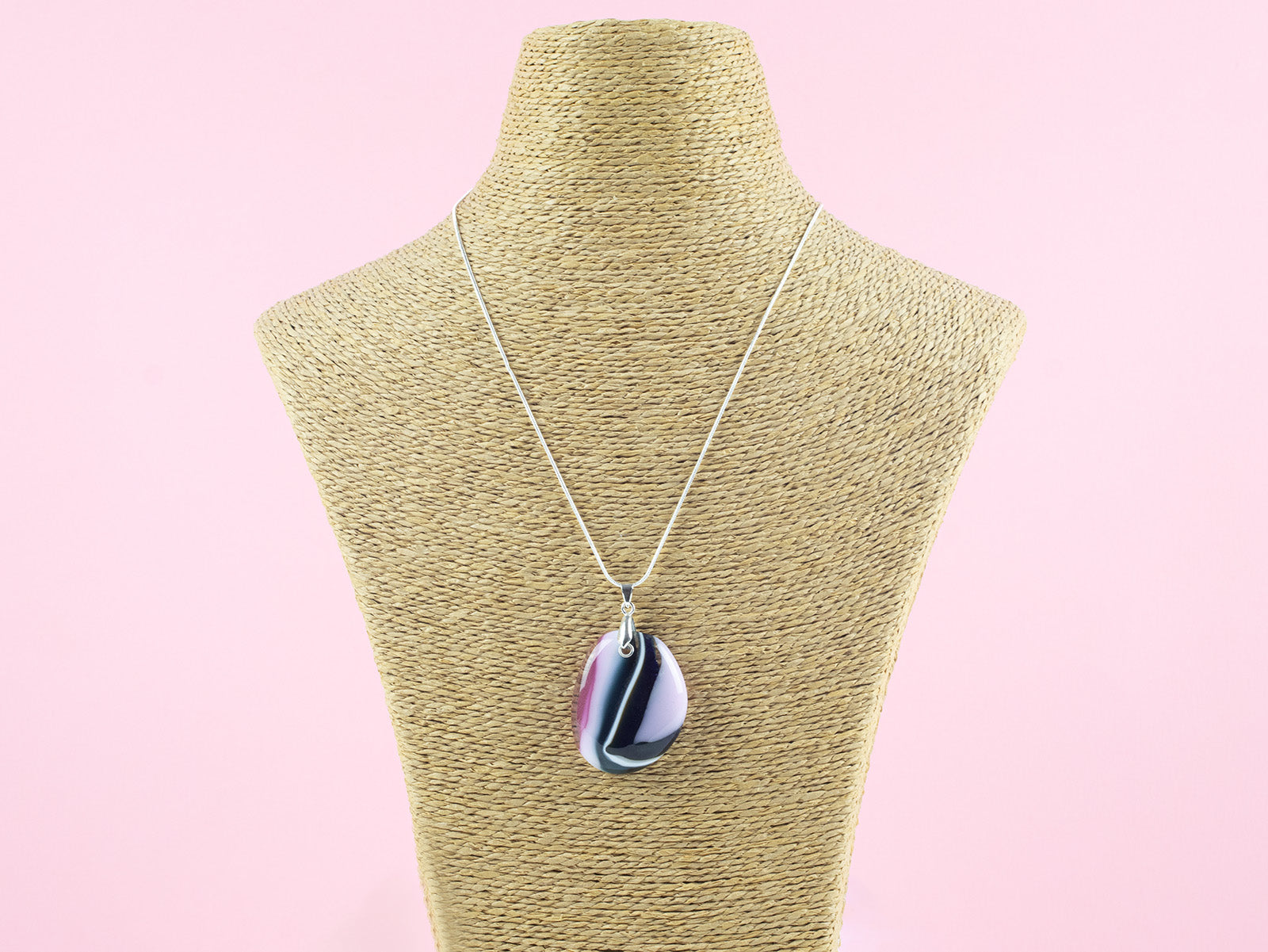 A fused glass pendant necklace hung on a sterling silver chain, handmade in heather pinks and organic deep hues. 