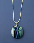 An artisan fused glass pendant necklace handcrafted in rich blues. Finished with a sterling silver chain and fittings.